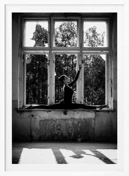 A black and white photograph of a graceful female dancer holding a perfect split on a large, dilapidated windowsill. She is silhouetted against the bright light from the broken window panes, with her arm elegantly raised. The setting is an abandoned room with peeling paint, creating a stark contrast between the dancer's elegance and the decaying environment. Wall Art