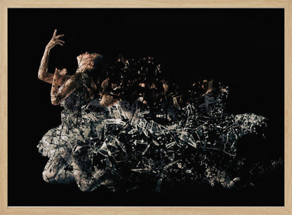 A conceptual piece of artwork depicting a woman in a dynamic pose against a solid black background. Her form appears to be shattering and dissolving into a swirling cloud of broken glass shards, creating a powerful and dramatic effect. The piece is presented within a simple silver frame. Print