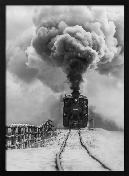 A dramatic black and white photograph of a vintage steam train on tracks in a snowy landscape, viewed from a low angle. A massive, powerful plume of dark smoke billows from the smokestack, filling the sky. Decor