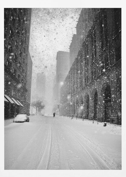 A grainy, black and white photograph captures a deserted city street during a heavy snowstorm. Tall buildings line the street, which is covered in a thick blanket of snow. A single car on the left is almost completely buried, and in the distance, a lone figure walks with an umbrella down the center of the empty road. Poster