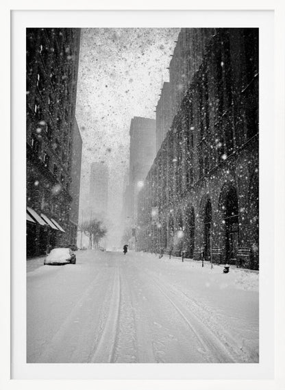 A grainy, black and white photograph captures a deserted city street during a heavy snowstorm. Tall buildings line the street, which is covered in a thick blanket of snow. A single car on the left is almost completely buried, and in the distance, a lone figure walks with an umbrella down the center of the empty road. Poster
