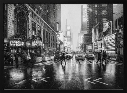 A moody black and white photograph of a snowy day in New York City's Times Square. The wet streets reflect the bright lights of the surrounding buildings and billboards as pedestrians cross the street and cars wait in traffic. Artwork