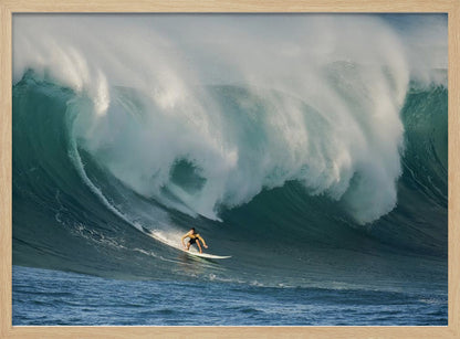 A lone surfer in a yellow shirt rides down the face of an enormous, powerful ocean wave as it crests into white foam, viewed within a silver picture frame. Wall Art