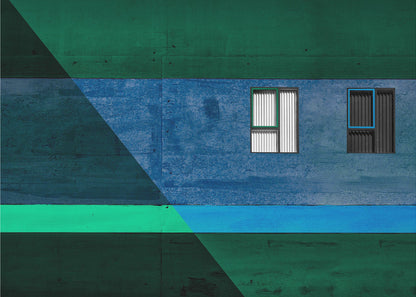 A framed abstract architectural photograph featuring a color-blocked facade. A central horizontal band of textured blue wall contains two small, distinct windows. This is flanked by upper and lower sections of dark green. A large, dark diagonal shape overlays the left side of the composition, creating sharp geometric lines. Decor