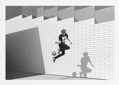 A framed, black and white photograph of a young person in mid-air, skillfully juggling a soccer ball with their foot against a clean, white brick wall. The person's shadow is cast sharply on the wall, mirroring the action, under a modern building with angled windows. Wall Art