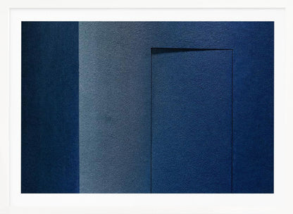 An abstract geometric artwork featuring textured panels in various shades of deep and dusty blue. The composition is divided into vertical sections, with a central rectangular shape that appears slightly recessed, creating a strong shadow line at its top edge. The piece is enclosed in a simple, brushed silver frame. Wall Art