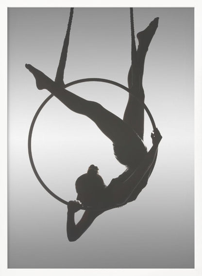 A black silhouette of a graceful female acrobat in an inverted pose on a suspended aerial hoop, set against a light grey background. Print