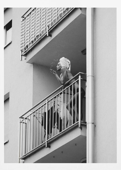 A black and white photo of a woman with a towel on her head, smoking a cigarette on an apartment balcony. The low-angle shot captures her leaning on the metal railing, with smoke drifting from the cigarette. Print