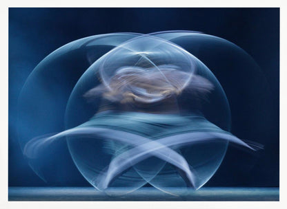 An abstract long-exposure photograph of a spinning dancer, creating ethereal, intersecting trails of blue and white light that form a glowing, orb-like shape against a deep blue background. The image is presented within a silver frame. Poster
