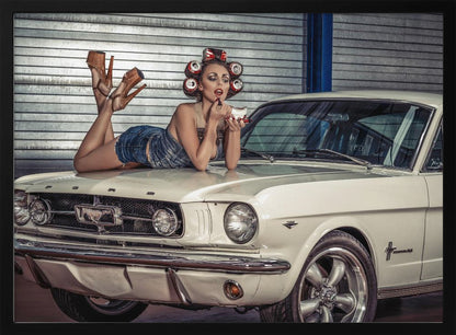 A woman in a retro pin-up style lies on the hood of a vintage white Ford Mustang in a garage, applying red lipstick with her hair set in soda can curlers. Poster