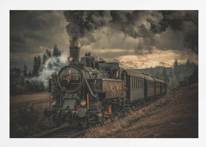 A powerful black steam locomotive on a railway track, billowing thick dark smoke into a dramatic, cloudy sky. The train travels through a rustic, grassy landscape, and the image has a warm, vintage color tone, all within a silver frame. Wall Art