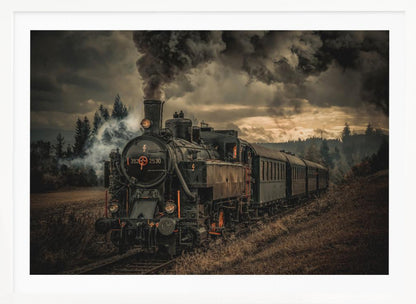A powerful black steam locomotive on a railway track, billowing thick dark smoke into a dramatic, cloudy sky. The train travels through a rustic, grassy landscape, and the image has a warm, vintage color tone, all within a silver frame. Wall Art
