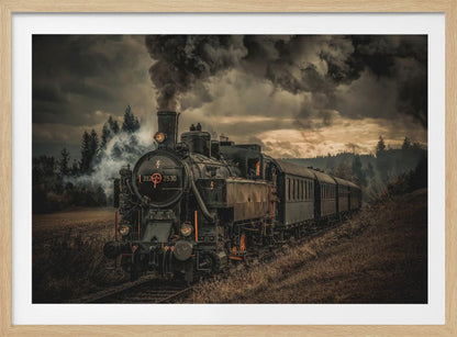 A powerful black steam locomotive on a railway track, billowing thick dark smoke into a dramatic, cloudy sky. The train travels through a rustic, grassy landscape, and the image has a warm, vintage color tone, all within a silver frame. Wall Art