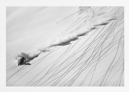 A dramatic black and white overhead photograph of a skier carving down a steep, powder-filled mountain slope, kicking up a huge plume of snow. Numerous ski tracks crisscross the pristine white snow, creating a pattern of dark lines. Poster