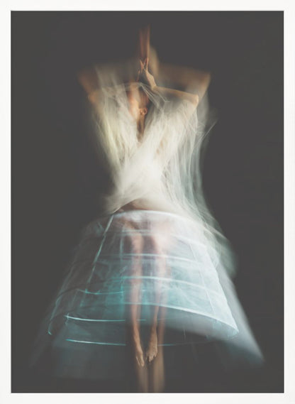 An ethereal, long-exposure photograph of a dancing figure against a dark gray background. The motion blur creates a ghostly effect, with white, gauzy fabric swirling around the upper body. The figure wears a transparent crinoline hoop skirt, revealing her legs and feet. Artwork