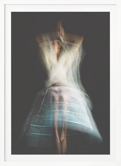 An ethereal, long-exposure photograph of a dancing figure against a dark gray background. The motion blur creates a ghostly effect, with white, gauzy fabric swirling around the upper body. The figure wears a transparent crinoline hoop skirt, revealing her legs and feet. Artwork