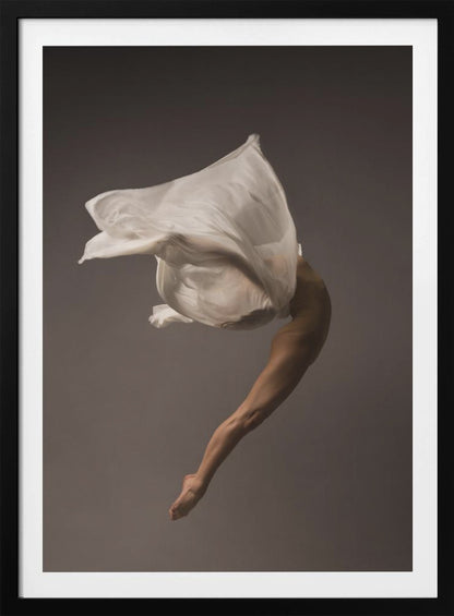 A minimalist fine art photograph of a dancer in mid-air against a solid grey background. The dancer's body is arched backwards, with a large piece of flowing white fabric enveloping their torso and creating a sense of dynamic, weightless motion. Only their muscular leg and pointed foot are clearly visible, emphasizing grace and form. Wall Art