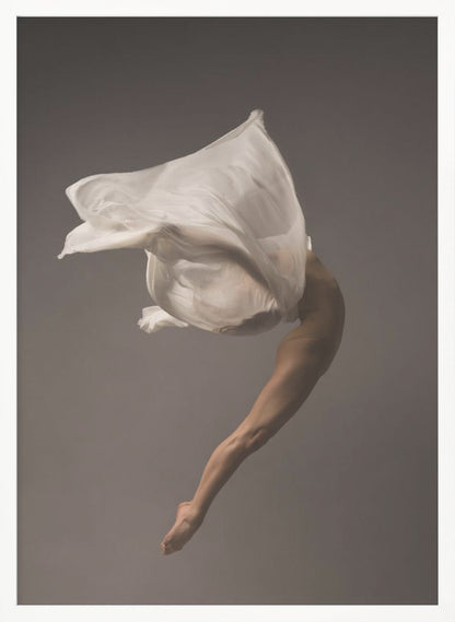 A minimalist fine art photograph of a dancer in mid-air against a solid grey background. The dancer's body is arched backwards, with a large piece of flowing white fabric enveloping their torso and creating a sense of dynamic, weightless motion. Only their muscular leg and pointed foot are clearly visible, emphasizing grace and form. Wall Art