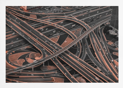 A framed aerial photograph of a sprawling, multi-level highway interchange presented in a selective color style. Dark grey roads weave over and under each other, while the surrounding land is a contrasting copper-brown, creating a dramatic and complex urban pattern. Poster
