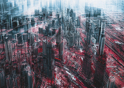 An abstract, digitally manipulated aerial photograph of a dense, futuristic cityscape. The image features towering skyscrapers in cool blue and dark gray tones, while the streets and ground below are saturated in a vibrant, contrasting red. The artwork has a glitchy, multi-exposure effect, creating a sense of dynamic chaos, and is enclosed in a silver frame. Artwork