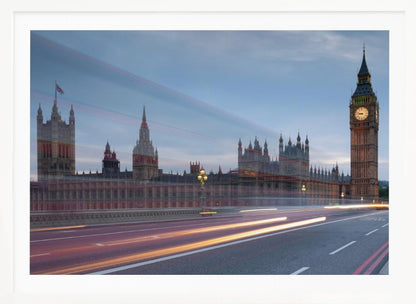 A framed, long-exposure photograph of London's Big Ben and the Houses of Parliament at dusk. In the foreground, streaks of red and yellow light from moving traffic blur across a bridge, creating a dynamic contrast with the historic architecture against a twilight sky. Decor