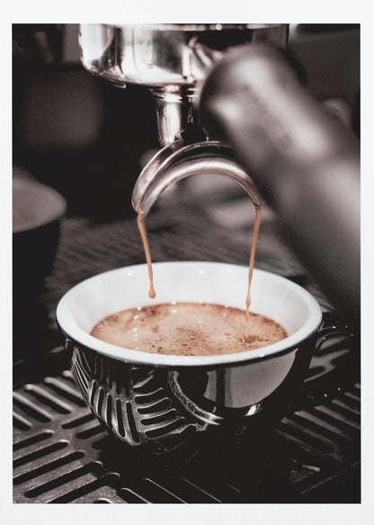 A close-up, desaturated photograph of an espresso machine pouring two streams of rich brown coffee from a chrome portafilter into an ornate black and white cup. Poster