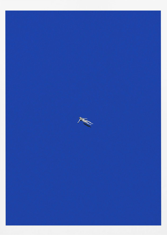 A minimalist and surreal artwork featuring a tiny, pale human figure floating peacefully in the center of an immense, solid, and vibrant blue void, all enclosed within a thin black frame. Wall Art