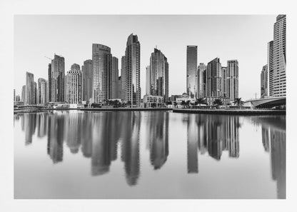 A framed black and white photograph of the Dubai Marina skyline, with its modern skyscrapers perfectly reflected in the calm water of the canal. Decor