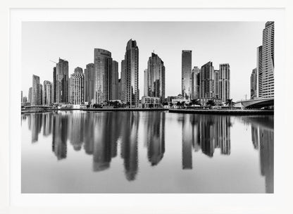 A framed black and white photograph of the Dubai Marina skyline, with its modern skyscrapers perfectly reflected in the calm water of the canal. Decor