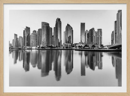 A framed black and white photograph of the Dubai Marina skyline, with its modern skyscrapers perfectly reflected in the calm water of the canal. Decor