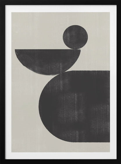A minimalist abstract artwork featuring three charcoal black shapes stacked against a light beige textured background. At the bottom is a large, rounded shape, on which a semi-circle is balanced. A smaller, full circle rests on top of the semi-circle, creating a sense of precarious balance. The piece is enclosed in a simple black frame. Decor