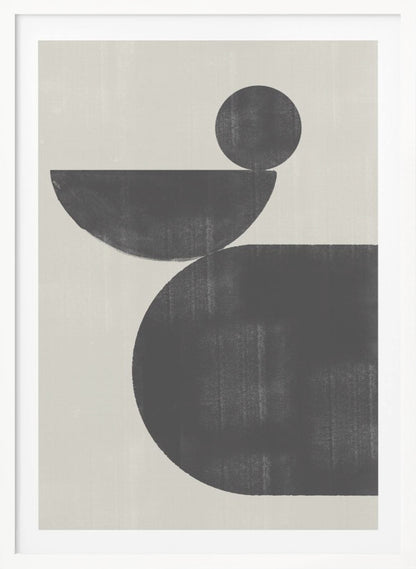 A minimalist abstract artwork featuring three charcoal black shapes stacked against a light beige textured background. At the bottom is a large, rounded shape, on which a semi-circle is balanced. A smaller, full circle rests on top of the semi-circle, creating a sense of precarious balance. The piece is enclosed in a simple black frame. Decor