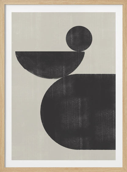 A minimalist abstract artwork featuring three charcoal black shapes stacked against a light beige textured background. At the bottom is a large, rounded shape, on which a semi-circle is balanced. A smaller, full circle rests on top of the semi-circle, creating a sense of precarious balance. The piece is enclosed in a simple black frame. Decor