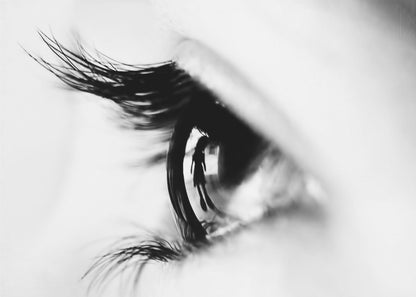 A dramatic black and white macro photograph of a human eye in profile, with a surreal reflection of a person's silhouette visible in the pupil. Print