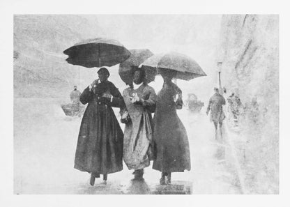 A vintage black and white photograph in a silver frame, depicting three people in long dark coats walking together under umbrellas during a heavy snow or rain storm on a city street. The image has a grainy, textured quality, giving it an old-fashioned, artistic feel. Poster