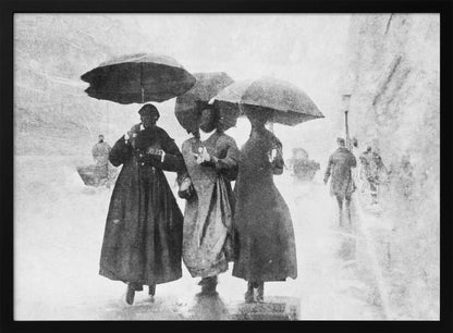 A vintage black and white photograph in a silver frame, depicting three people in long dark coats walking together under umbrellas during a heavy snow or rain storm on a city street. The image has a grainy, textured quality, giving it an old-fashioned, artistic feel. Poster