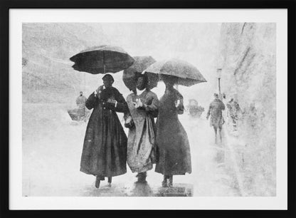 A vintage black and white photograph in a silver frame, depicting three people in long dark coats walking together under umbrellas during a heavy snow or rain storm on a city street. The image has a grainy, textured quality, giving it an old-fashioned, artistic feel. Poster