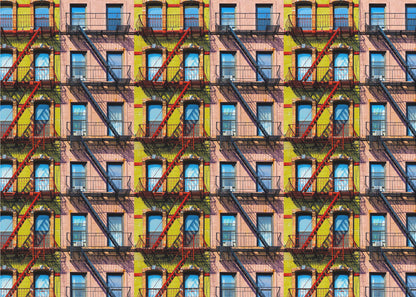 A pop-art style repeating pattern of a colorful apartment building facade featuring pink and yellow walls, windows reflecting a blue sky, and a network of black and red fire escapes, enclosed in a silver frame. Artwork