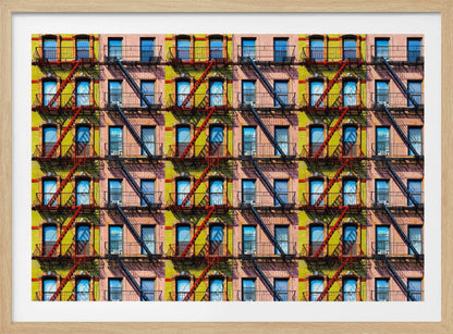 A pop-art style repeating pattern of a colorful apartment building facade featuring pink and yellow walls, windows reflecting a blue sky, and a network of black and red fire escapes, enclosed in a silver frame. Artwork