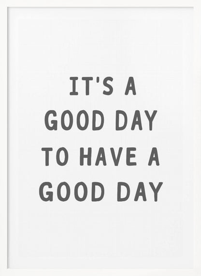 A framed black and white art print with the phrase 'IT'S A GOOD DAY TO HAVE A GOOD DAY' in a bold, dark gray, sans-serif font. Artwork