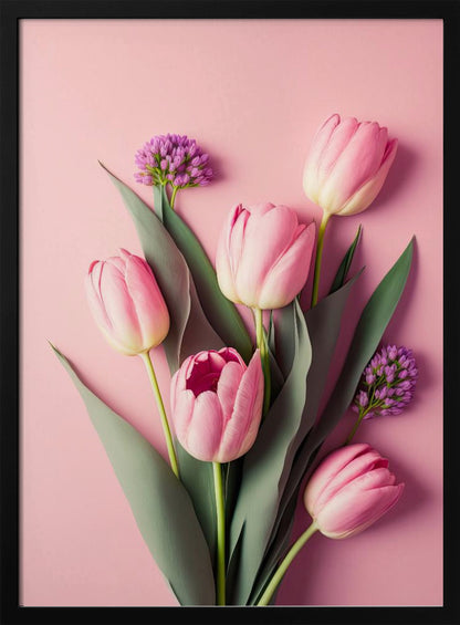 A top-down, artistic illustration of a bouquet of pink tulips and small purple flowers with long green leaves, arranged against a solid light pink background and displayed within a thin black frame. Wall Art