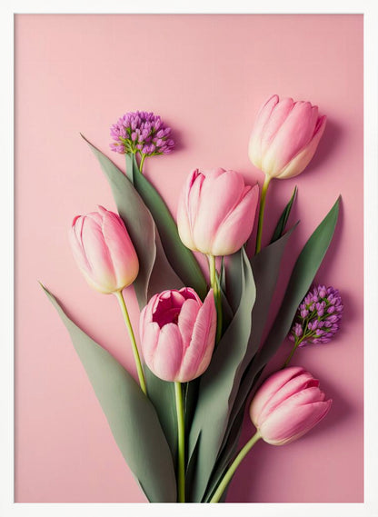 A top-down, artistic illustration of a bouquet of pink tulips and small purple flowers with long green leaves, arranged against a solid light pink background and displayed within a thin black frame. Wall Art