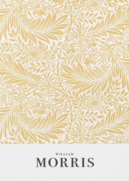 A framed exhibition-style poster of a William Morris design. The poster features an intricate, golden-yellow floral and leaf pattern on a white background. Below the pattern, the name 'WILLIAM MORRIS' is printed in black text. The entire artwork is presented in a simple black frame. Wall Art