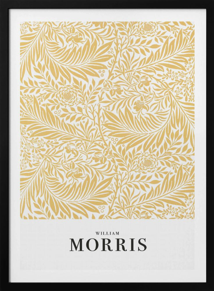 A framed exhibition-style poster of a William Morris design. The poster features an intricate, golden-yellow floral and leaf pattern on a white background. Below the pattern, the name 'WILLIAM MORRIS' is printed in black text. The entire artwork is presented in a simple black frame. Wall Art