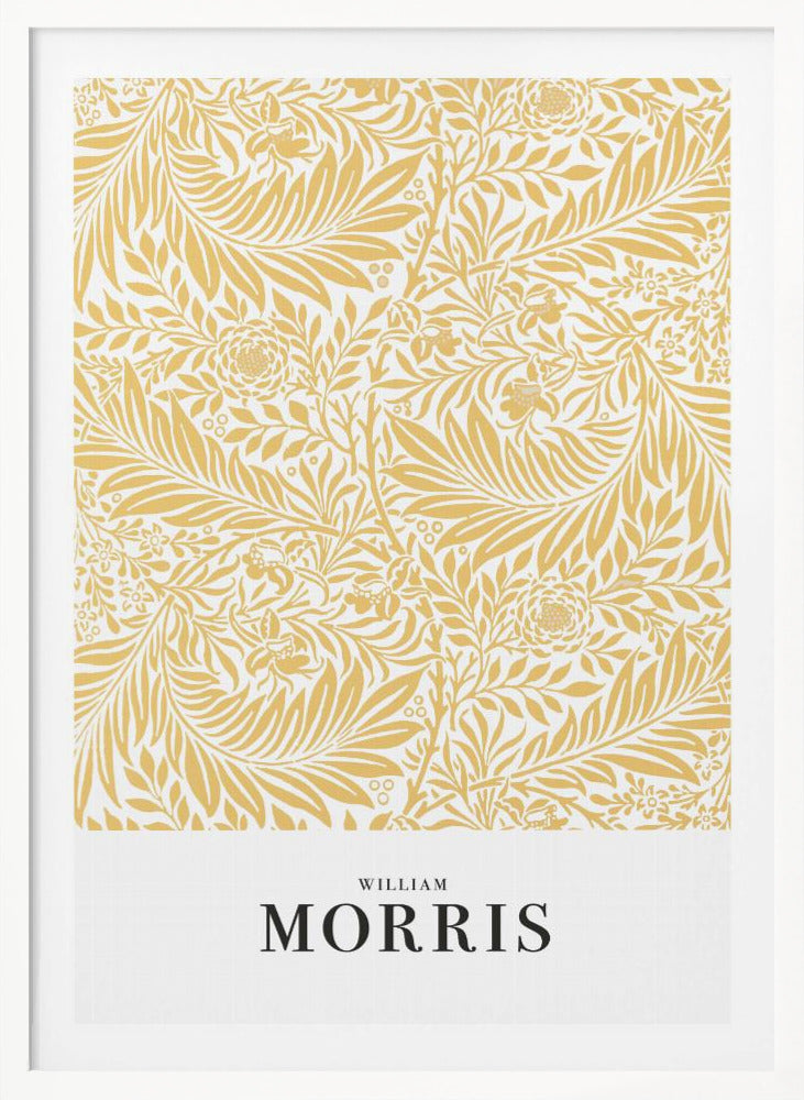 A framed exhibition-style poster of a William Morris design. The poster features an intricate, golden-yellow floral and leaf pattern on a white background. Below the pattern, the name 'WILLIAM MORRIS' is printed in black text. The entire artwork is presented in a simple black frame. Wall Art