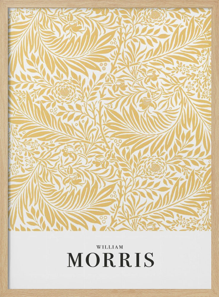 A framed exhibition-style poster of a William Morris design. The poster features an intricate, golden-yellow floral and leaf pattern on a white background. Below the pattern, the name 'WILLIAM MORRIS' is printed in black text. The entire artwork is presented in a simple black frame. Wall Art