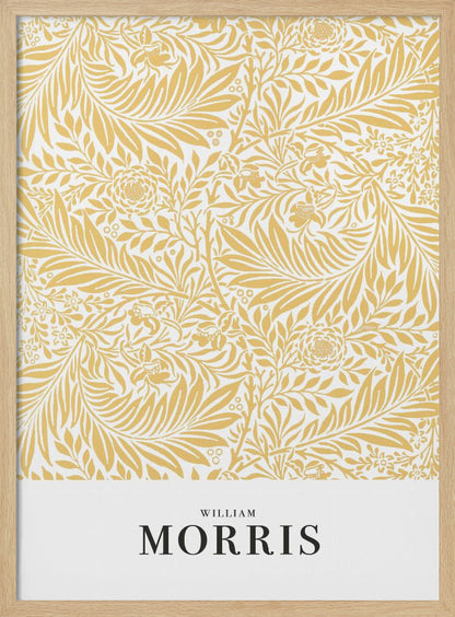 A framed exhibition-style poster of a William Morris design. The poster features an intricate, golden-yellow floral and leaf pattern on a white background. Below the pattern, the name 'WILLIAM MORRIS' is printed in black text. The entire artwork is presented in a simple black frame. Wall Art