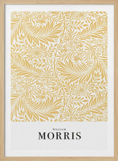 A framed exhibition-style poster of a William Morris design. The poster features an intricate, golden-yellow floral and leaf pattern on a white background. Below the pattern, the name 'WILLIAM MORRIS' is printed in black text. The entire artwork is presented in a simple black frame. Wall Art