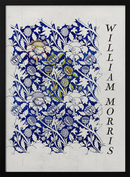 A vintage art print by William Morris featuring an intricate blue and white floral pattern on a light gray, textured background. The design swatch shows stylized flowers and acanthus leaves, with some central flowers highlighted in yellow and peach. The name 'WILLIAM MORRIS' is printed vertically in a black serif font along the right edge. The print is displayed in a thin black frame. Decor
