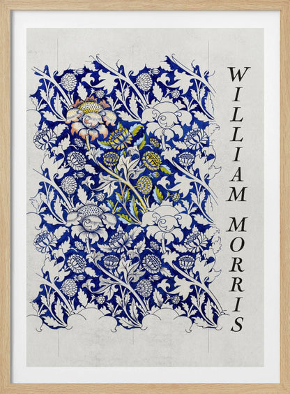 A vintage art print by William Morris featuring an intricate blue and white floral pattern on a light gray, textured background. The design swatch shows stylized flowers and acanthus leaves, with some central flowers highlighted in yellow and peach. The name 'WILLIAM MORRIS' is printed vertically in a black serif font along the right edge. The print is displayed in a thin black frame. Decor